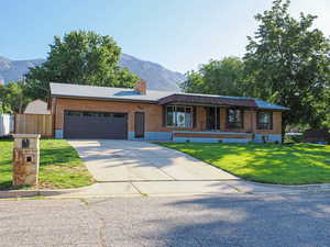 Ranch-style home featuring brick siding, a mountain view, and a garage