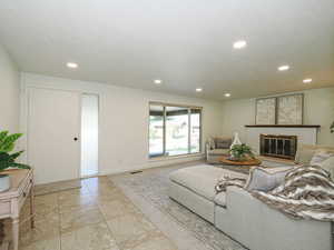 Living room with recessed lighting and a fireplace