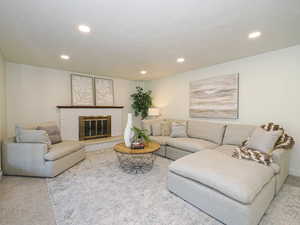 Living area featuring recessed lighting, carpet flooring, and a brick fireplace