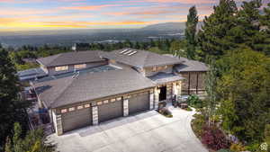 Prairie-style house featuring a garage, concrete driveway, roof with shingles, and stone siding