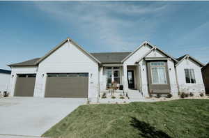 Modern inspired farmhouse with board and batten siding, an attached garage, concrete driveway, and a front yard