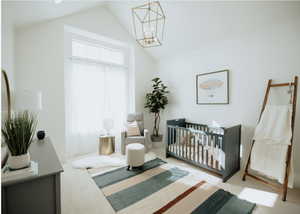 Carpeted bedroom featuring vaulted ceiling and a chandelier