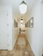 Hallway featuring light wood-style flooring and baseboards