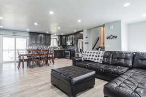 Living area with healthy amount of natural light, recessed lighting, and light wood finished floors