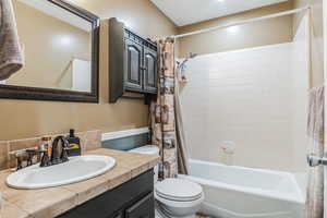 Bathroom featuring vanity and shower / bathtub combination with curtain