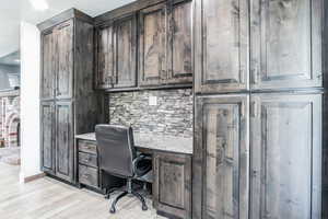 Home office featuring built in desk and light wood-type flooring
