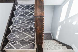 Staircase featuring baseboards and carpet floors