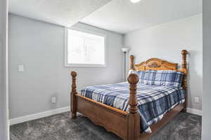 Bedroom featuring carpet and a textured ceiling