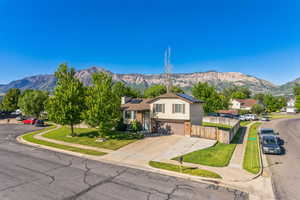 Split level home featuring a mountain view, solar panels, a garage, and brick siding