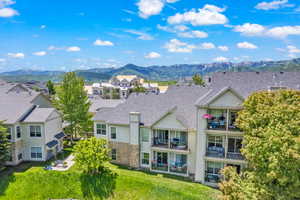 Rear view of property with a mountain view, a residential view, and roof with shingles