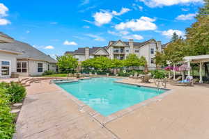 Community pool with a patio area, a pergola, and a residential view