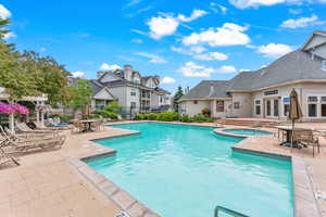 Community pool featuring a hot tub, french doors, a patio, and a residential view