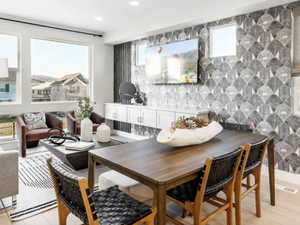 Dining space with light wood-style floors and recessed lighting