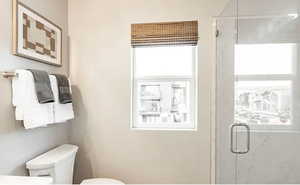 Full bathroom featuring toilet and a shower stall