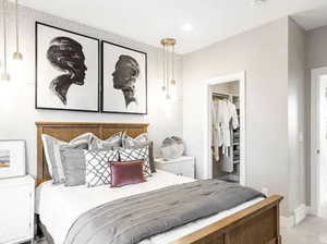 Bedroom featuring a walk in closet and light colored carpet