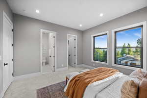 Bedroom featuring light colored carpet, recessed lighting, and ensuite bathroom