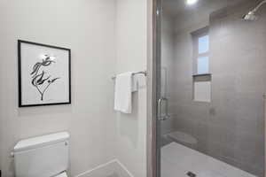 Full bathroom with toilet and a shower stall