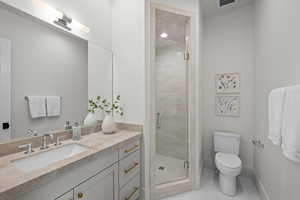 Bathroom with vanity, a stall shower, and tile patterned flooring