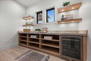 Detailed view of beverage cooler, wood finished floors, and bar area