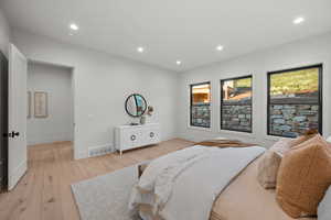 Bedroom with light wood-style floors and recessed lighting