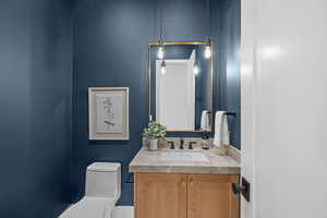 Half bathroom with vanity and toilet