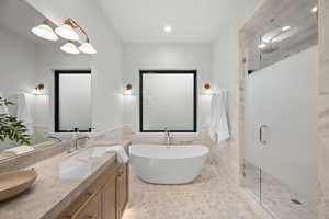 Full bathroom featuring tile walls, a shower stall, double vanity, a wainscoted wall, and a freestanding tub