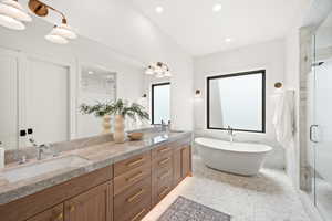 Full bath with tile walls, double vanity, a marble finish shower, a soaking tub, and recessed lighting