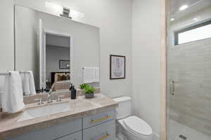 Full bathroom featuring connected bathroom, vanity, and a stall shower