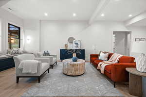 Living room featuring light wood-type flooring, recessed lighting, and beamed ceiling