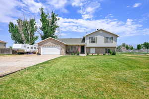 Split level home with brick siding, concrete driveway, and a garage