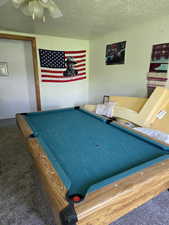 Recreation room with carpet flooring, billiards table, a textured ceiling, and a ceiling fan