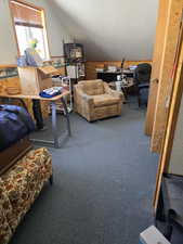 Carpeted office featuring a textured ceiling and vaulted ceiling