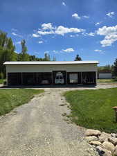 View of outdoor structure featuring driveway and a carport