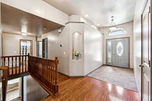 Foyer entrance with a textured ceiling and wood finished floors