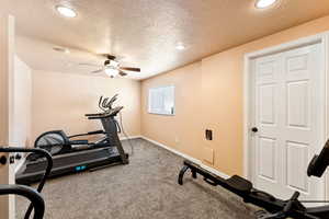 Exercise area with ceiling fan, a textured ceiling, recessed lighting, and carpet