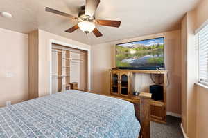 Bedroom with carpet flooring, ceiling fan, and a closet