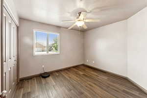 Unfurnished bedroom featuring wood finished floors, a closet, a ceiling fan, and a textured ceiling