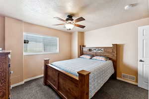 Bedroom featuring carpet, a textured ceiling, and ceiling fan