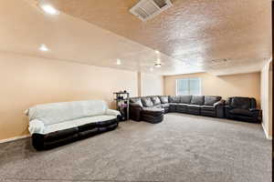 Carpeted living room with a textured ceiling and recessed lighting