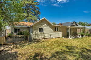 Rear view of house featuring a lawn and a patio