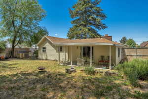 Rear view of house with an outdoor fire pit, a patio, roof with shingles, and a chimney