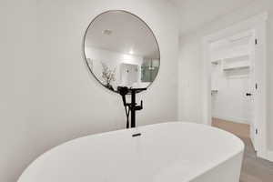 Bathroom view of a freestanding bath and a spacious closet