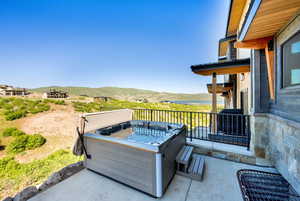 View of patio / terrace with area for grilling and a water and mountain view