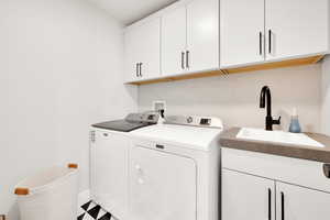 Laundry area with washer and clothes dryer and cabinet space