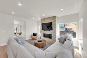 Living area featuring a fireplace, wood finished floors, healthy amount of natural light, and recessed lighting