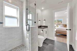 Bathroom with ensuite bathroom, a shower stall, vanity, recessed lighting, and tile patterned flooring