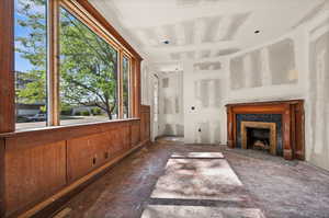 Unfurnished living room featuring plenty of natural light and a tile fireplace