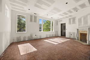 Unfurnished living room with plenty of natural light and a tile fireplace