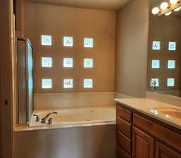 Bathroom with vanity and a jetted tub