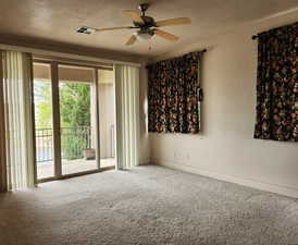 Carpeted spare room featuring ceiling fan and a textured ceiling
